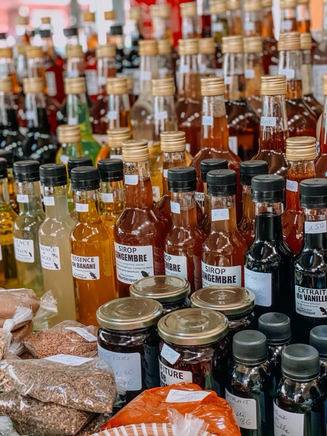 Étal de sirops, d’épices et de confitures sur un marché de Martinique.