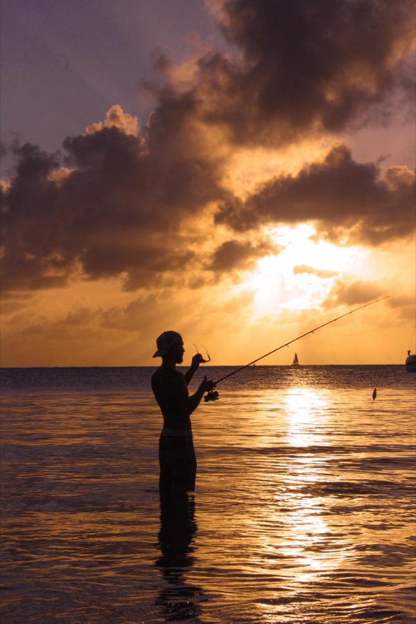 Silhouette d’un pêcheur au coucher du soleil sur la côte de Martinique.
