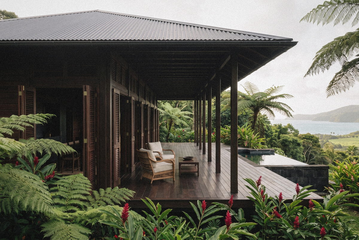 La galerie de la Villa Rivière vue du jardin : toit sur poteaux, fauteuils et bord de la piscine face à la mer.
